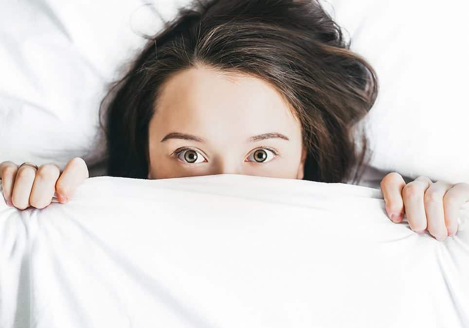 Picture of a woman lying in bed awake to illustrate the symptoms of insomnia. Insomnia treatment is available from Kathryn Tipton LPC in Houston, Texas 77006.