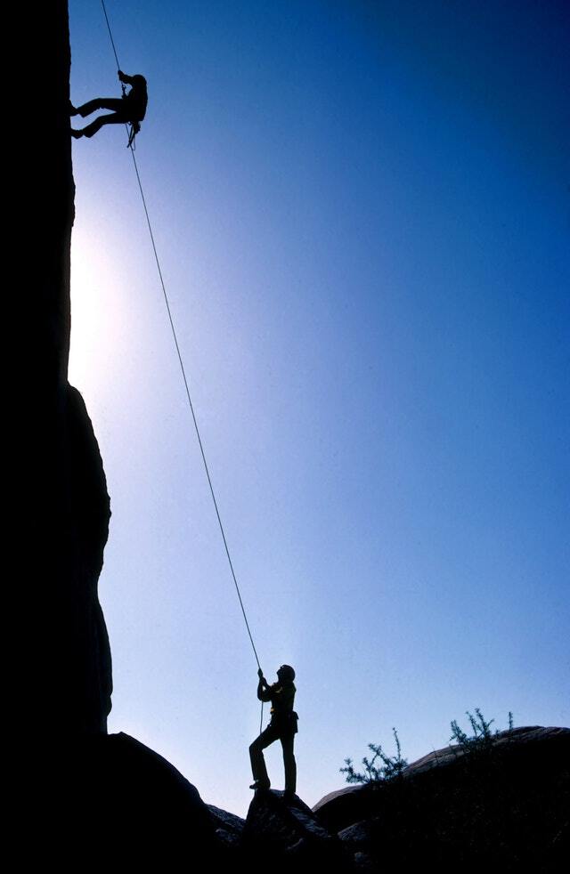 Photo of one person helping another climb a mountain to illustrate getting help for anxiety. Anxiety Treatment in Houston, Texas 77006