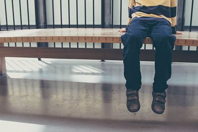 Photo of boy sitting on bench to illustrate child therapy Houston, TX 77006