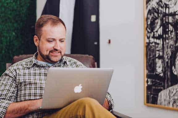 Man sitting at computer to illustrate online therapy Houston, TX