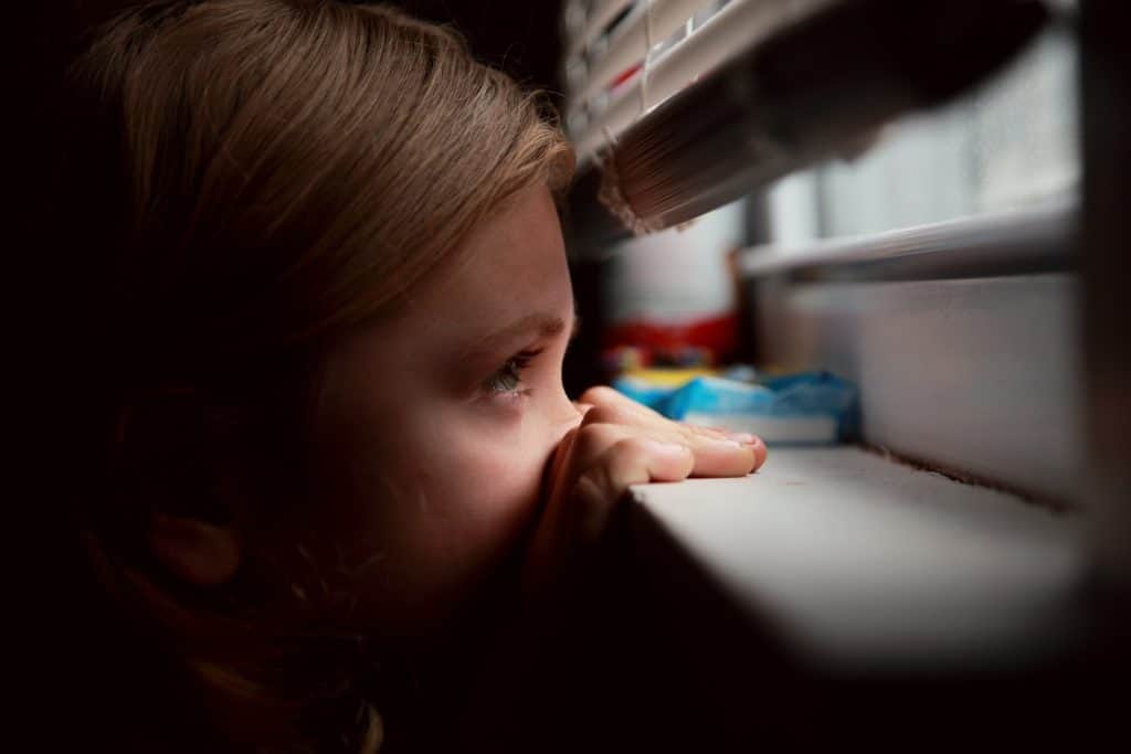 Photo of child looking out window to illustrate anxiety in children Houston, Texas 